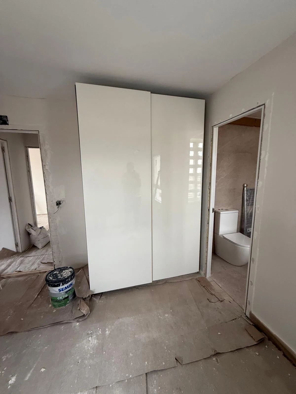 Armario blanco de puertas lisas montado en una vivienda en reforma