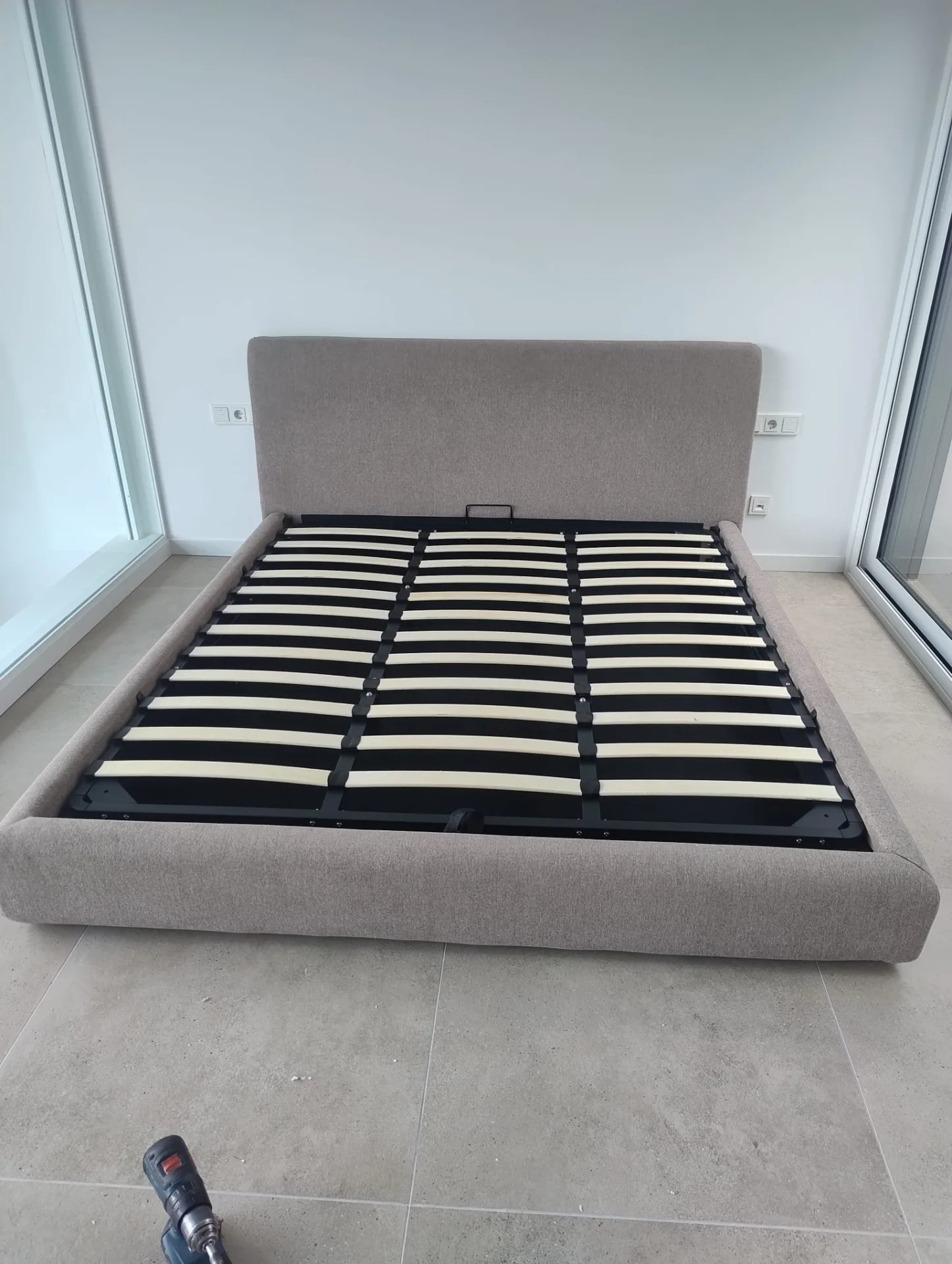 Cama canapé con cabecero gris y somier de láminas montada