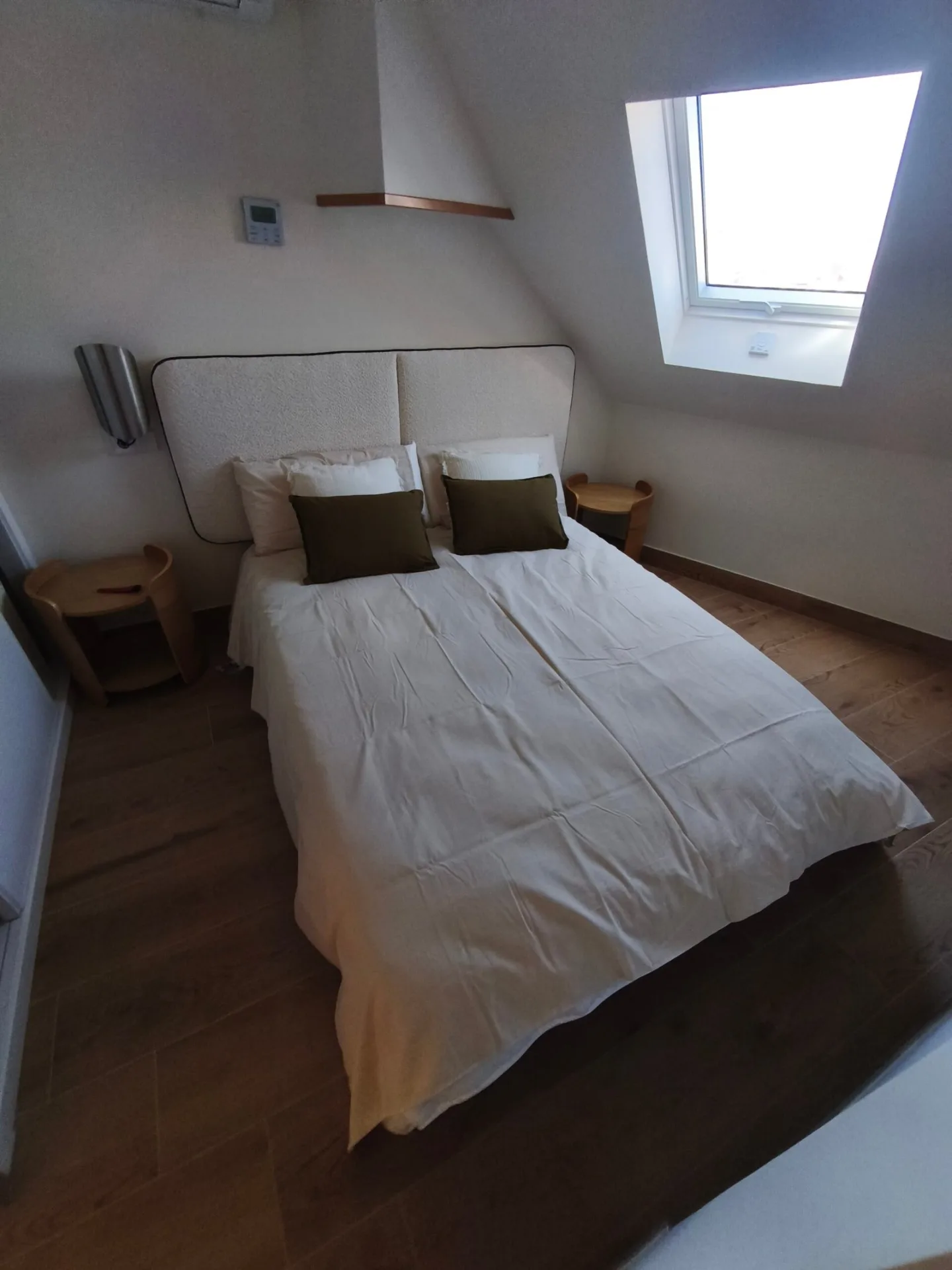 Dormitorio con cama de matrimonio, cabecero y mesitas de noche