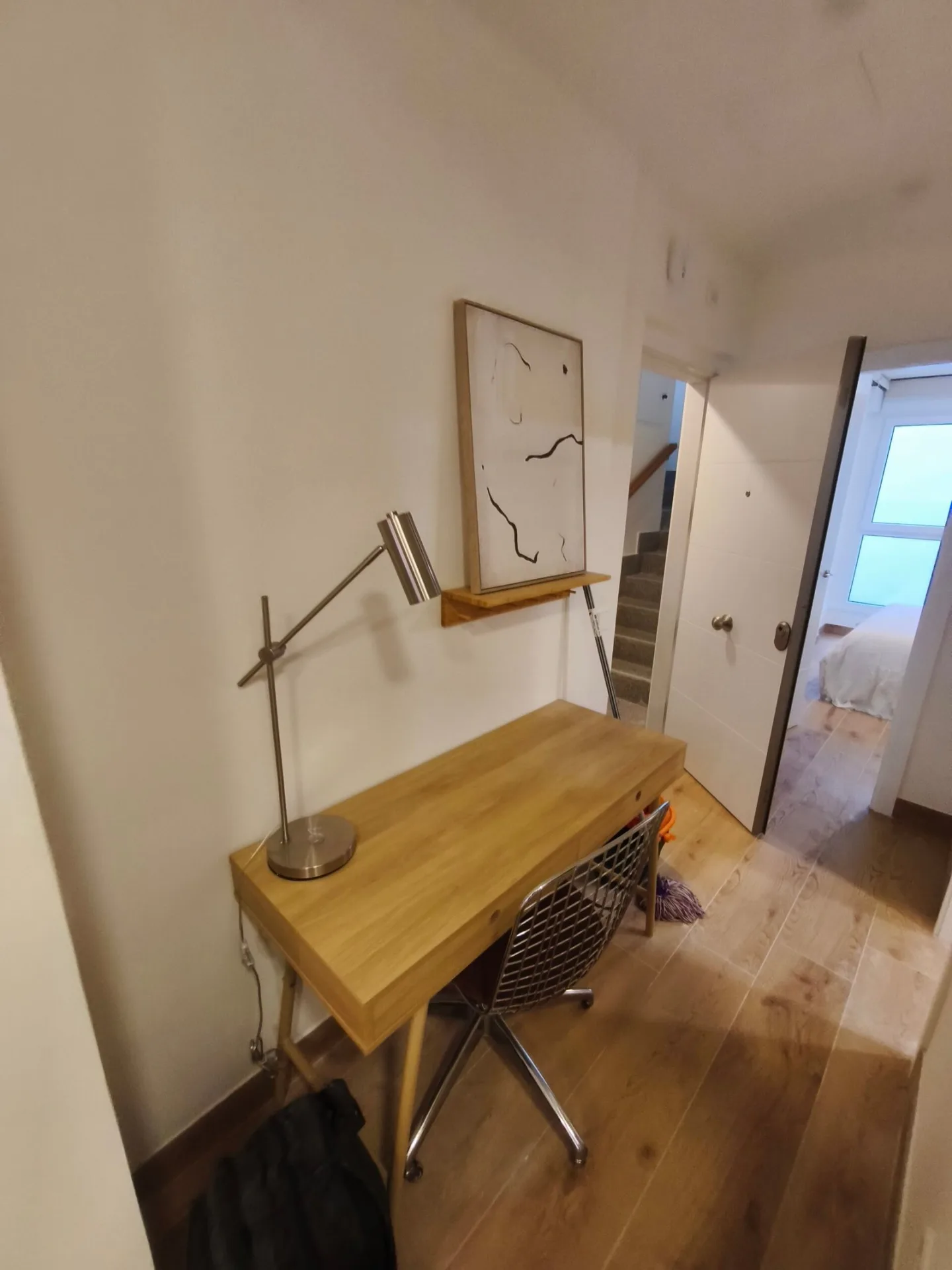 Escritorio de madera con lámpara de brazo en un rincón de trabajo