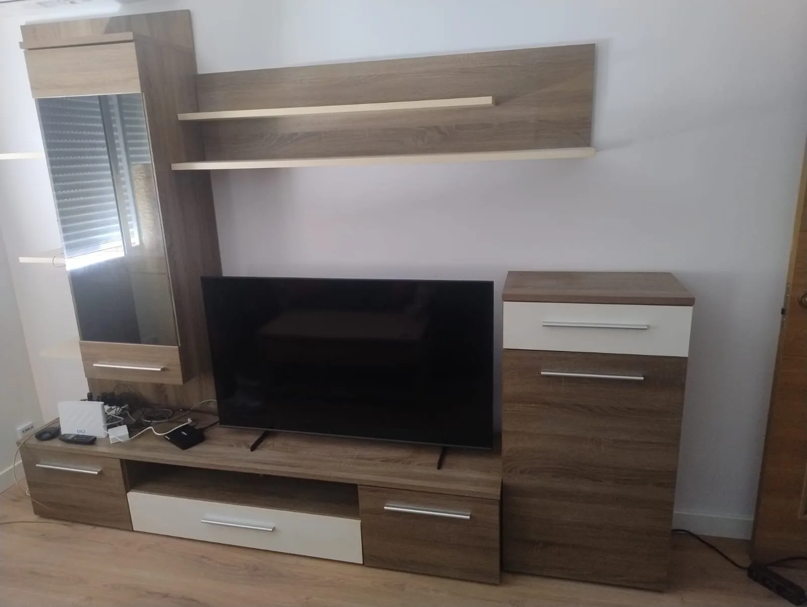 Mueble de salón modular con TV, estantes y módulos blancos