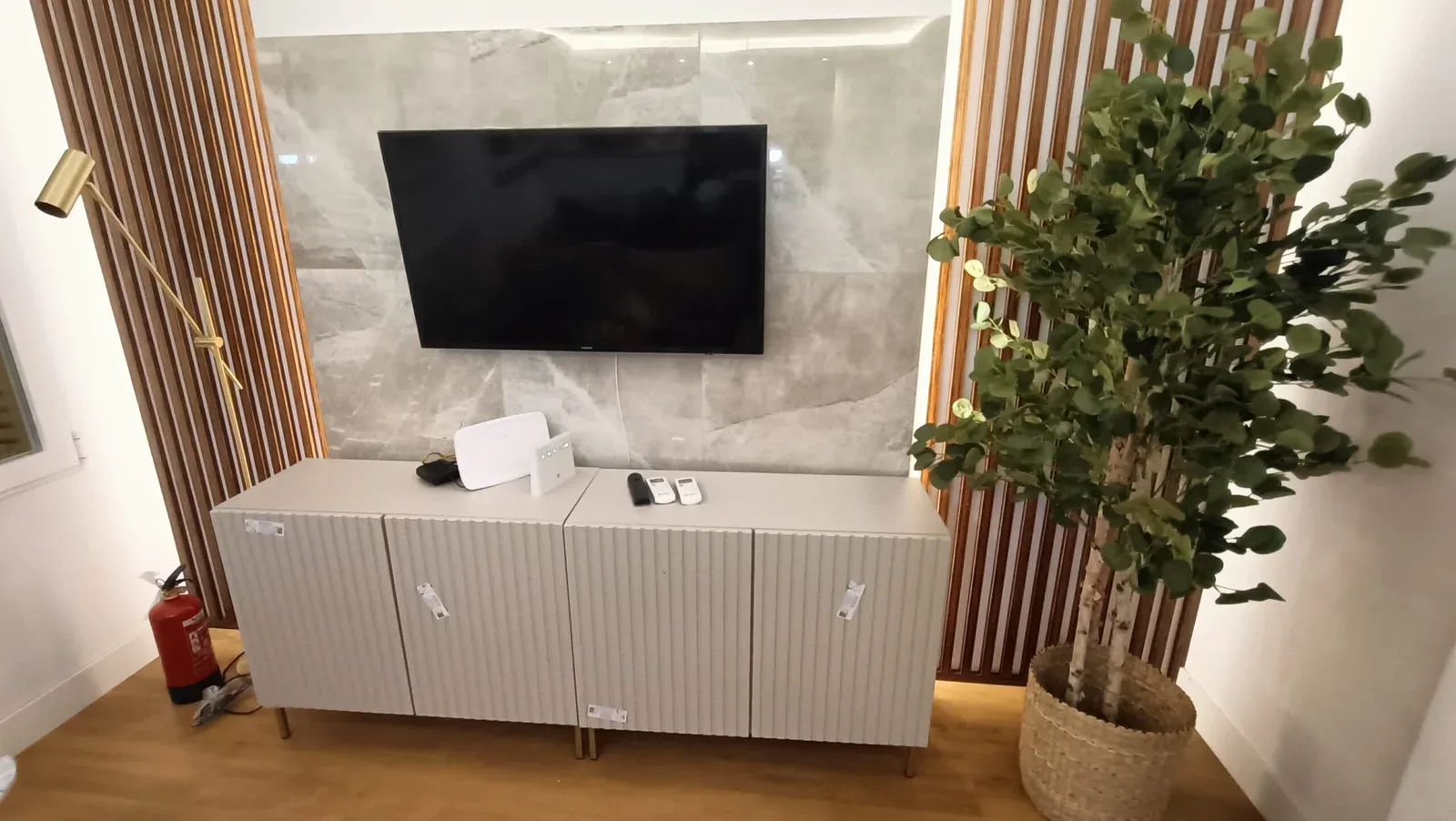 Mueble de TV blanco con lamas de madera montado
