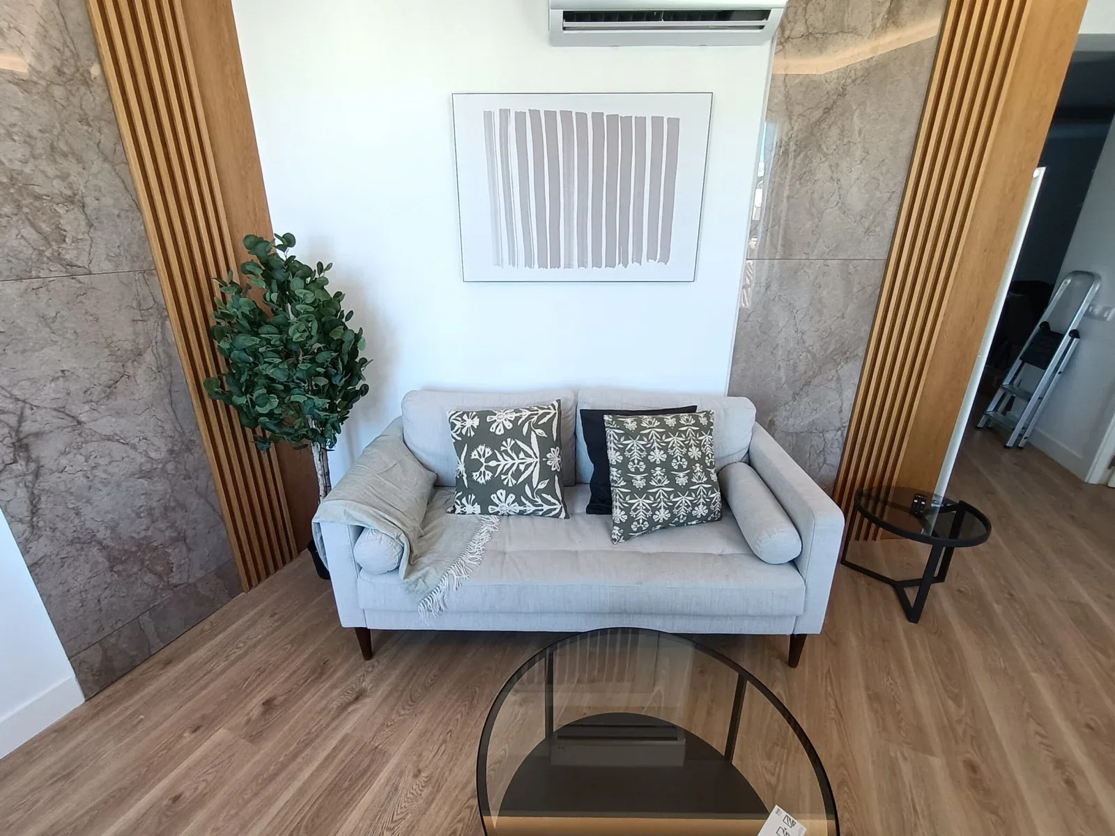 Salón con sofá y lamas de madera en la pared