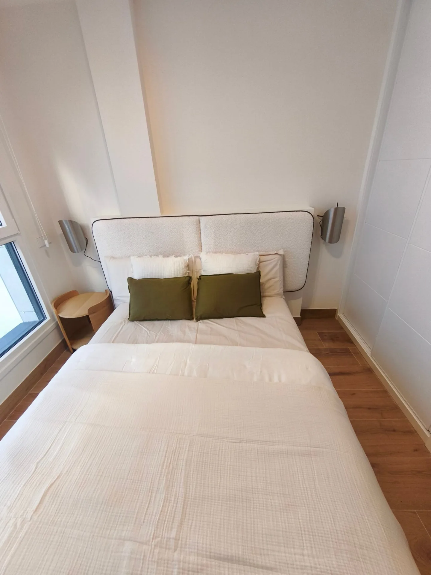 Dormitorio con cama grande, cabecero y mesitas de noche de madera