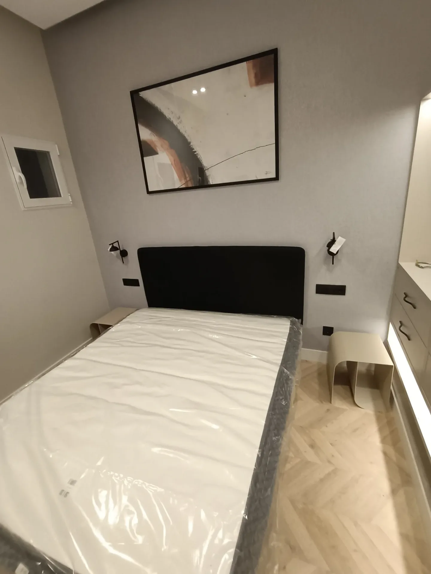 Habitación con cama y cabecero negro montados