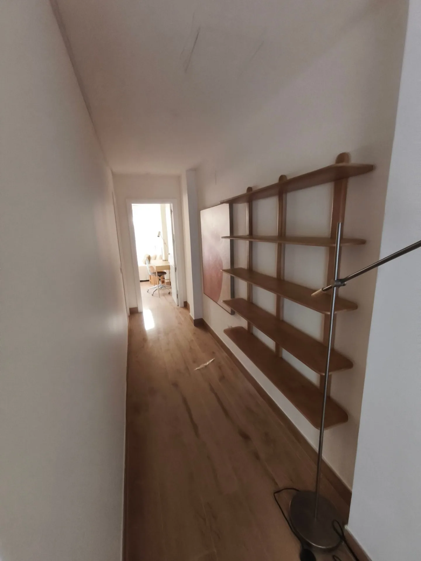 Pasillo con estantería de madera montada y suelo de tarima