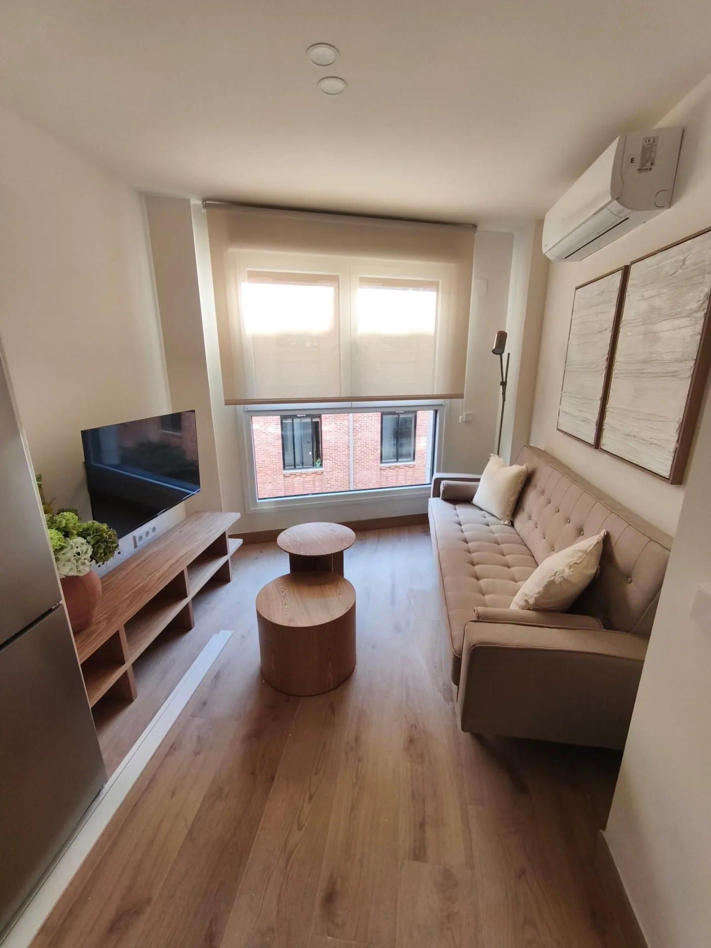 Salón con sofá, mesa de centro y mueble de TV en un piso amueblado