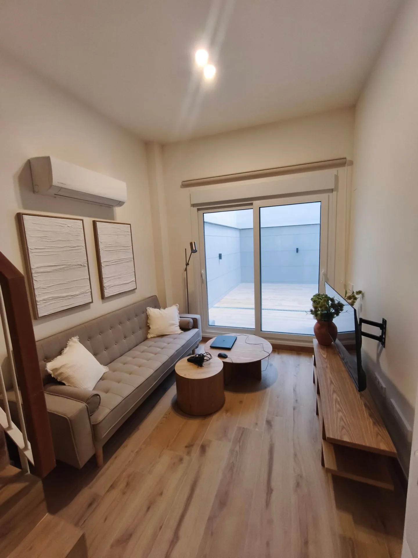 Salón amueblado con sofá, mesa de centro y mueble de TV en un piso de alquiler