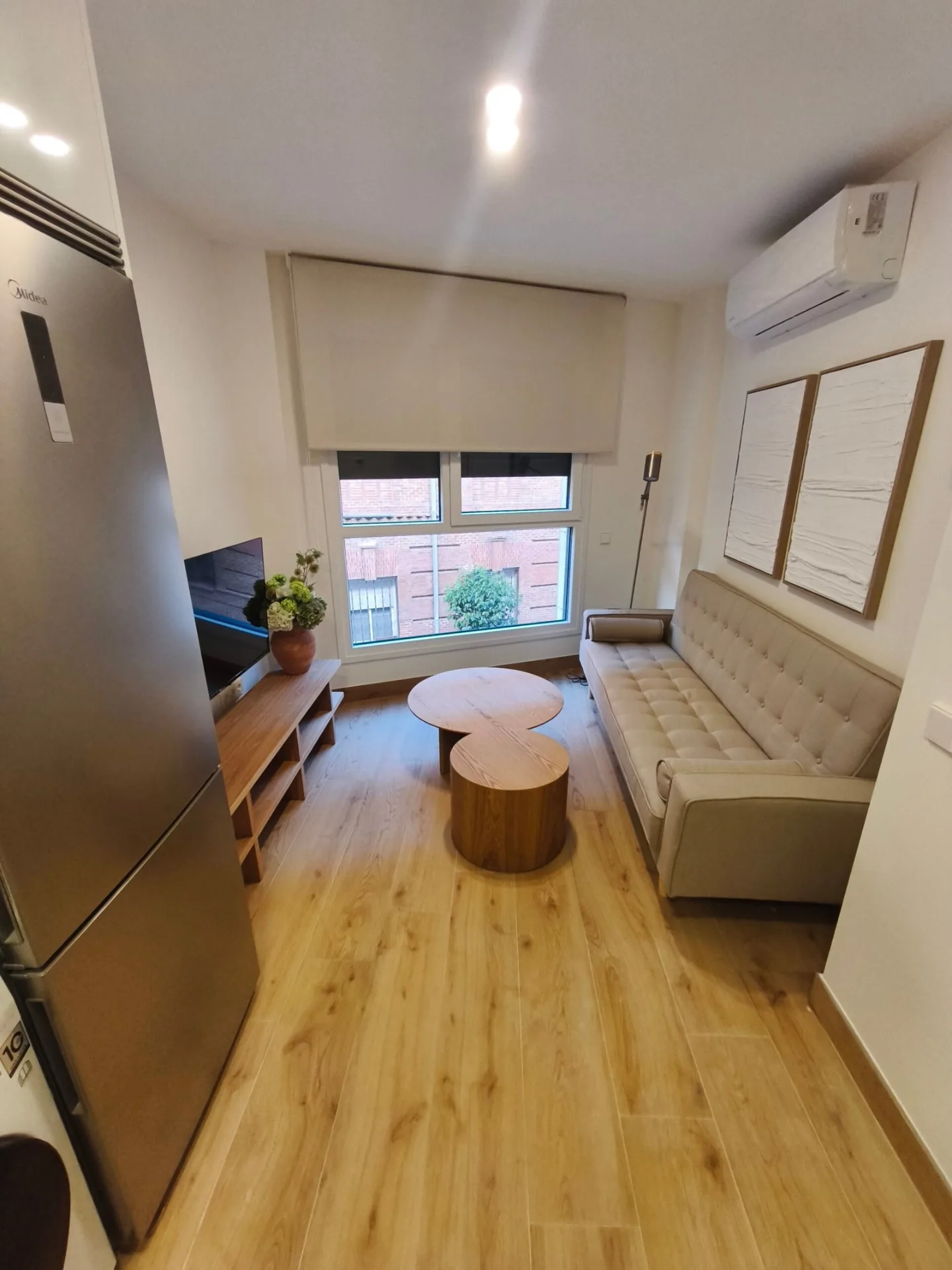 Salón con sofá y mueble de TV visto desde la entrada